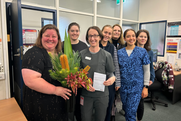 Austin Health Allied Health team members standing with a beautiful vase of flowers and foliage